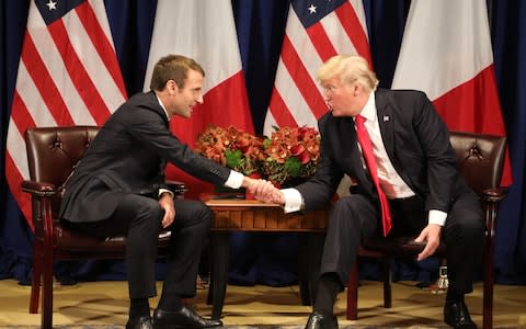 France's president Emmanuel Macron (L) and US President Donald Trump shake hands before a meeting  - Credit: AFP