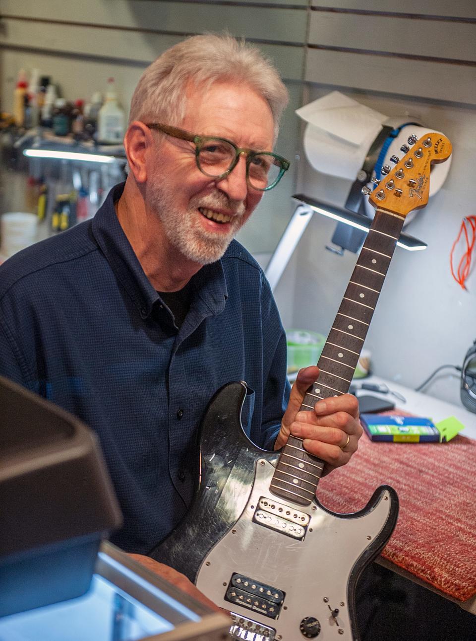 At Centre Music House in Framingham, Corbit Larson works on a guitar, Oct. 13, 2023. The business is marking its 50th anniversary.