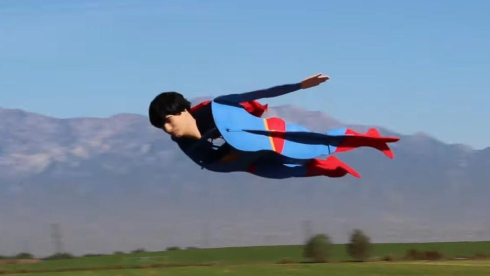 A remote-controlled Superman in his blue and red suit flying in the sky