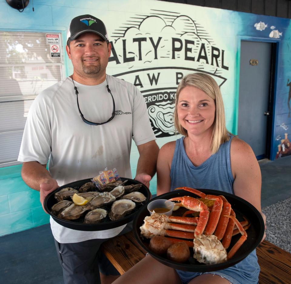  Matt and Lisa Carstens, the Salty Pearl Restaurant owners , show off a sampling of the most popular seafood items on the new Perdido Key area eatery's menu on Friday, Aug. 4, 2023.  