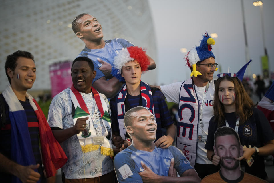 Soccer fans pose with pictures of France's Kylian Mbappe and France's goalkeeper Hugo Lloris ahead of the World Cup round of 16 soccer match between France and Poland, at the Al Thumama Stadium in Doha, Qatar, Sunday, Dec. 4, 2022. (AP Photo/Christophe Ena)