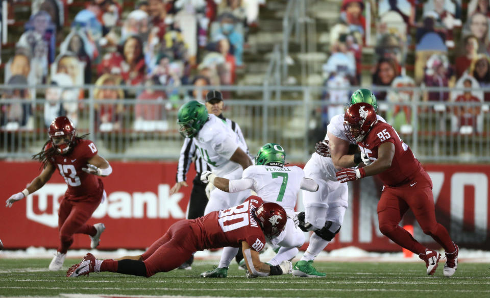 CJ Verdell #7 of the Oregon Ducks is tackled by Brennan Jackson #80 of the Washington State Cougars in the first half at Martin Stadium on Nov. 14. (William Mancebo/Getty Images)