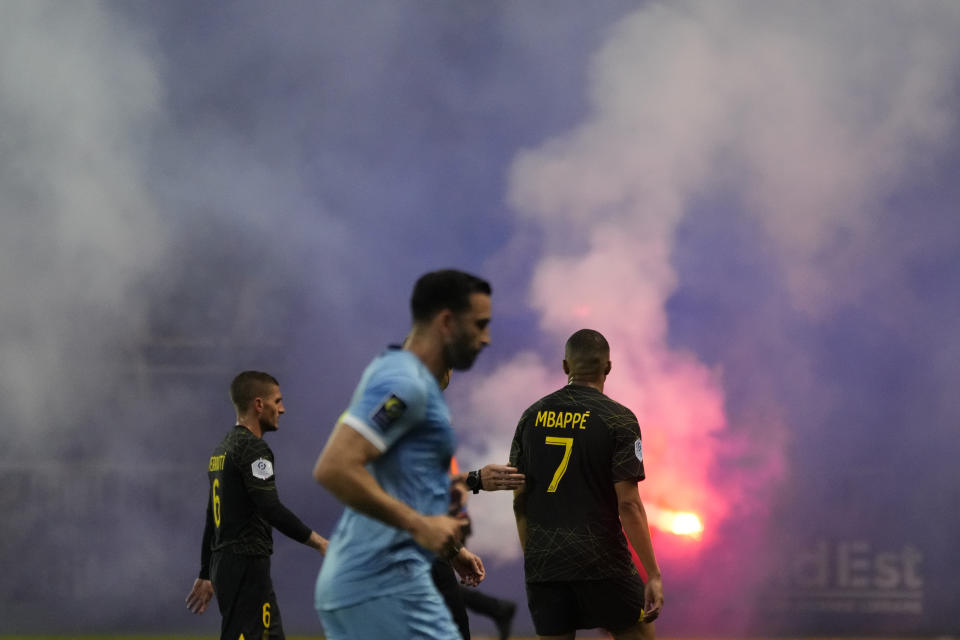 Fans burn flare during the French League One soccer match between Troyes and Paris Saint Germain, at the Stade de l'Aube, in Troyes, France, Sunday, May 7, 2023. (AP Photo/Lewis Joly)