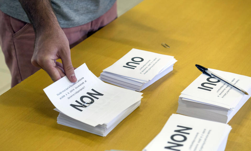 A man prepares to cast his vote at a polling station in Noumea, New Caledonia, as part of an independence referendum, Sunday, Nov. 4, 2018. Voters in New Caledonia are deciding whether the French territory in the South Pacific should break free from the European country that claimed it in the mid-19th century. (AP Photo/Mathurin Derel)