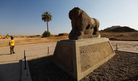 A man looks at the statue of the Lion of Babylon in the ancient city of Babylon near Hilla