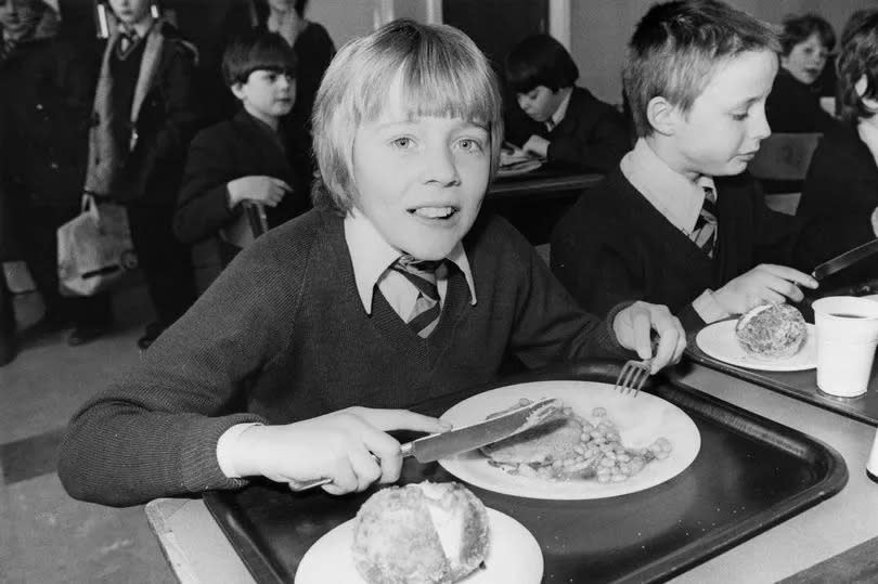 A boy tucks into his school dinner in the 80s