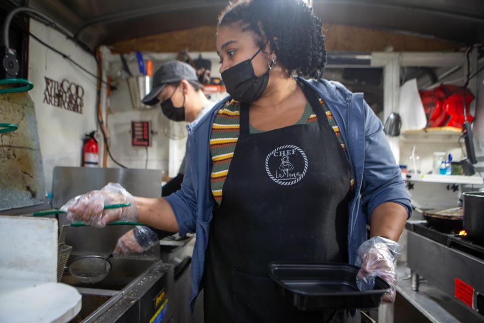 LaMona Scroggins, owner of Chef LaMona, prepares a plate of fried fish for her popular catfish sandwiches. She often parks at 115 S.W. 29th St.