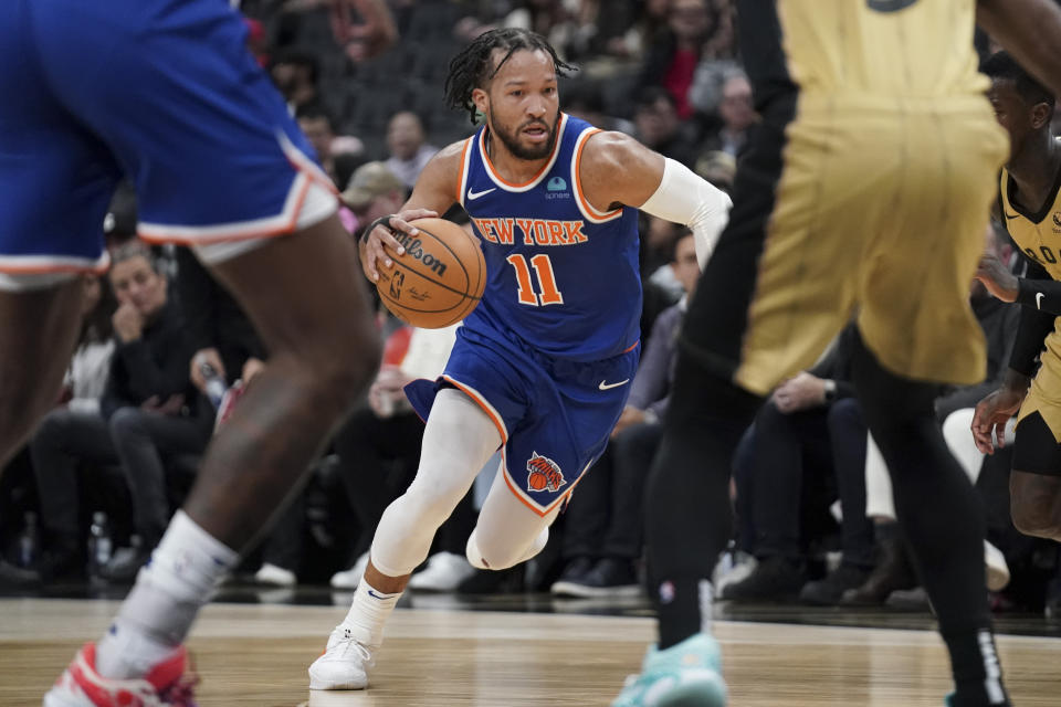 New York Knicks guard Jalen Brunson (11) drives at the Toronto Raptors defense during second-half NBA basketball game action in Toronto, Friday, Dec. 1, 2023. (Arlyn McAdorey/The Canadian Press via AP)