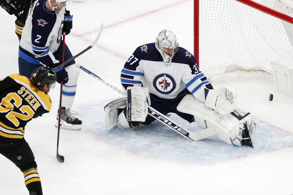 Boston Bruins' Oskar Steen (62) scores on Winnipeg Jets' Connor Hellebuyck (37) during the first period of an NHL hockey game, Saturday, Jan. 22, 2022, in Boston. (AP Photo/Michael Dwyer)