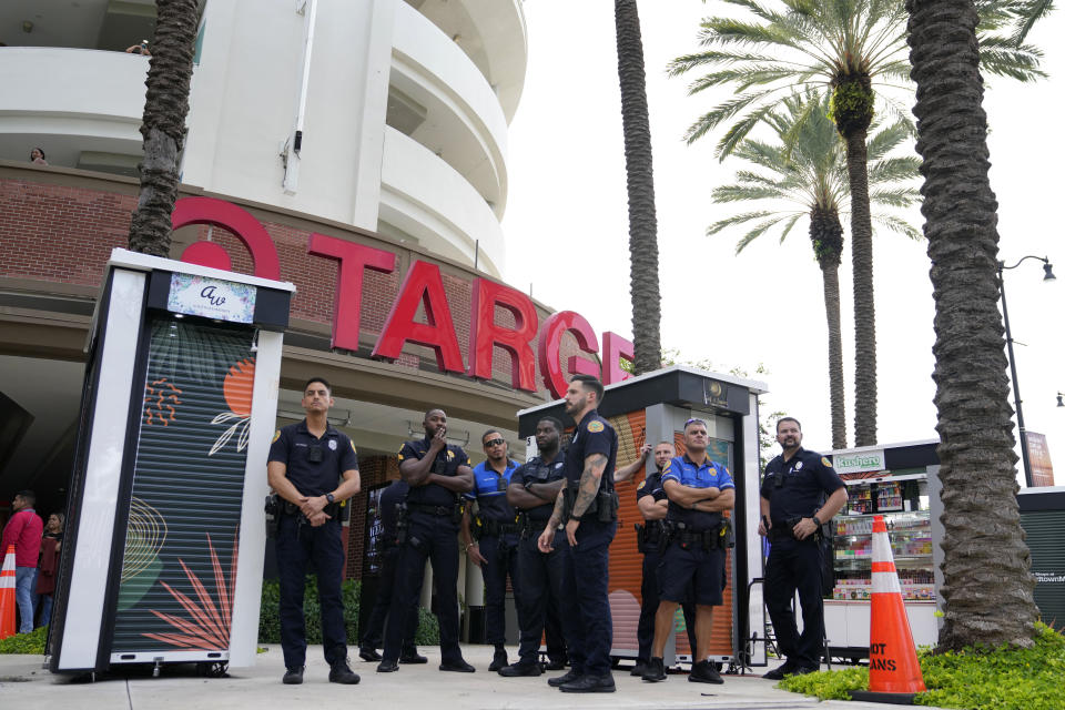 FILE - Police officers stand outside a Target store as a group of people protest across the street, Thursday, June 1, 2023, in Miami. Longtime Pride sponsors like Bud Light and Target have come under attack by conservatives for their LGBTQ-friendly marketing. (AP Photo/Lynne Sladky, File)