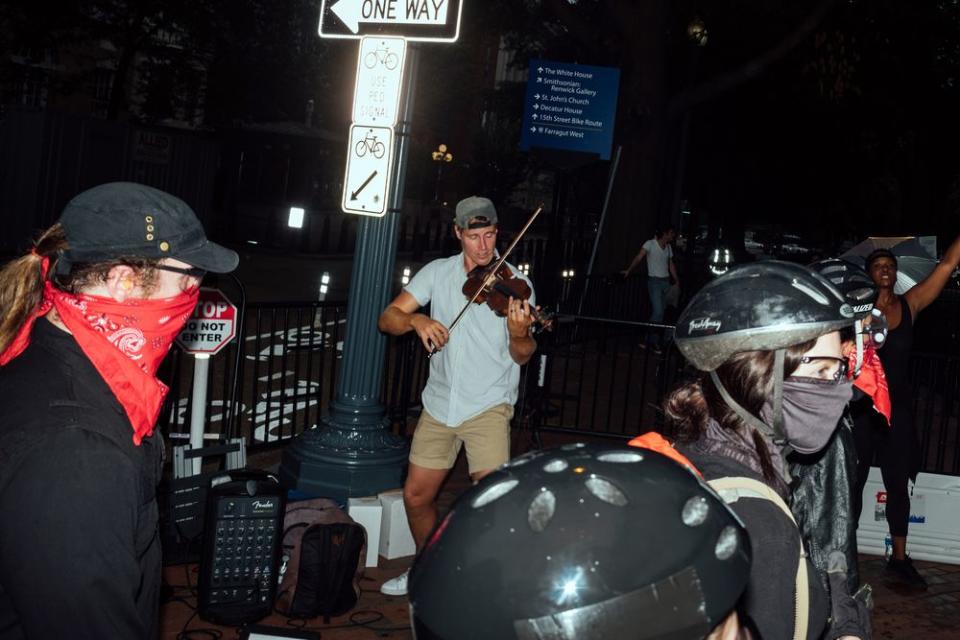 Anti-fascist demonstrators pass a busker in downtown Washington.