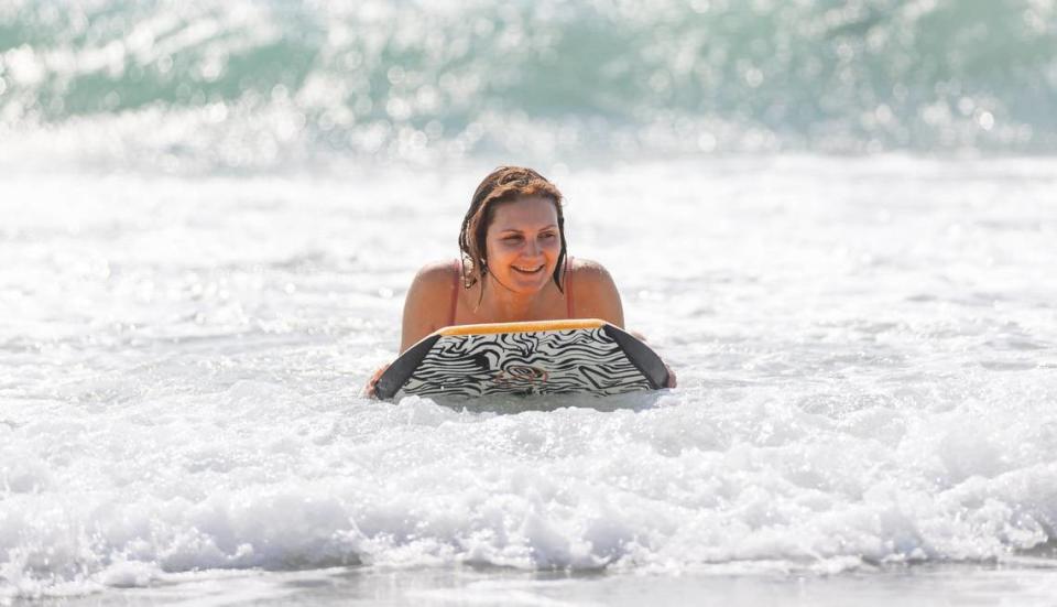 Angelina uses a body board to catch waves near the Hollywood Beach Broadwalk as temperatures soar into the 90s on Tuesday, May 14, 2024, in Hollywood, Fla.