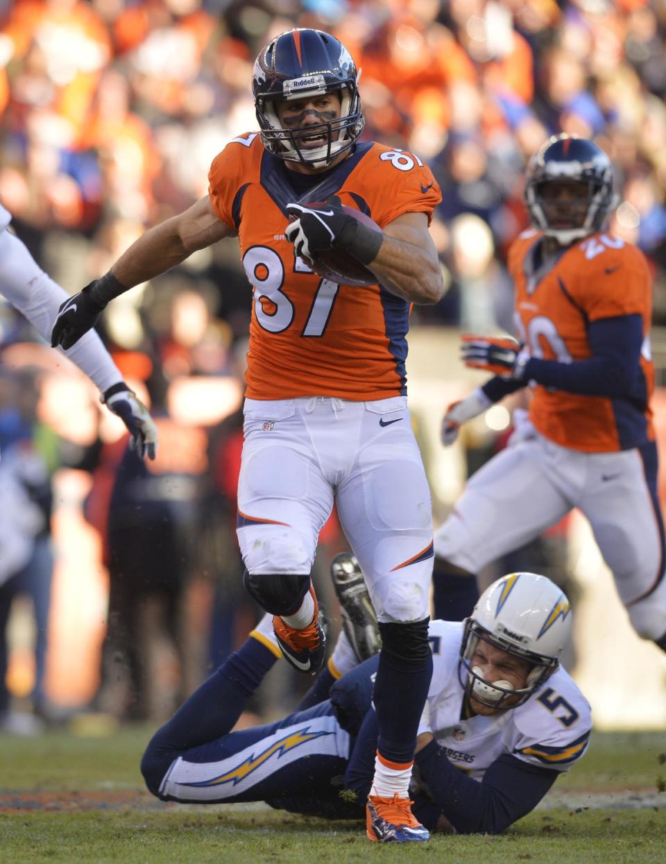 Denver Broncos wide receiver Eric Decker (87) slips away from San Diego Chargers punter Mike Scifres (5) on a return in the second quarter of an NFL AFC division playoff football game, Sunday, Jan. 12, 2014, in Denver. Scifres was injured on the play. (AP Photo/Jack Dempsey)