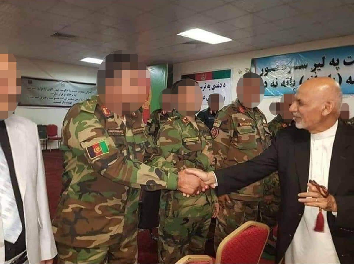 The Afghan colonel shakes hands with the Afghan president at the time, Ashraf Ghani (The Independent)