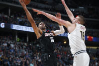 Houston Rockets forward Thabo Sefolosha, left, drives to the rim for a basket past Denver Nuggets center Nikola Jokic in the first half of an NBA basketball game Sunday, Jan. 26, 2020, in Denver. (AP Photo/David Zalubowski)