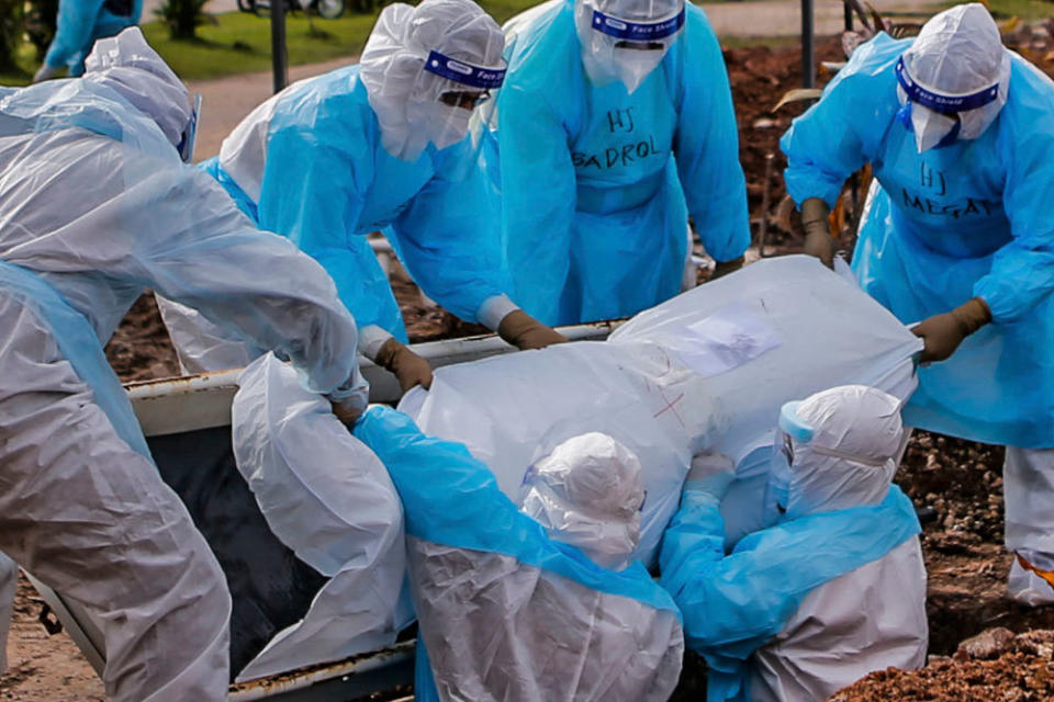 Workers in personal protective equipment bury the body of a Covid-19 victim at the Muslim cemetery in Section 21, Shah Alam, July 10, 2021. ― Picture by Hari Anggara