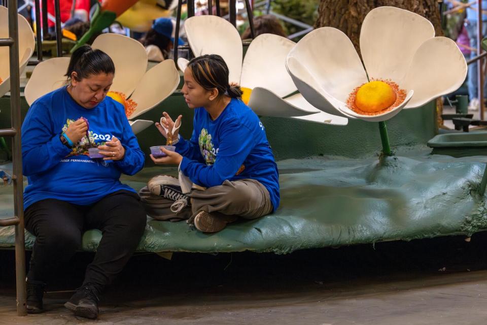 Cynthia Willie, left, and her 13-year-old daughter, Jocelyn Carino, chop straw flowers to little pieces.