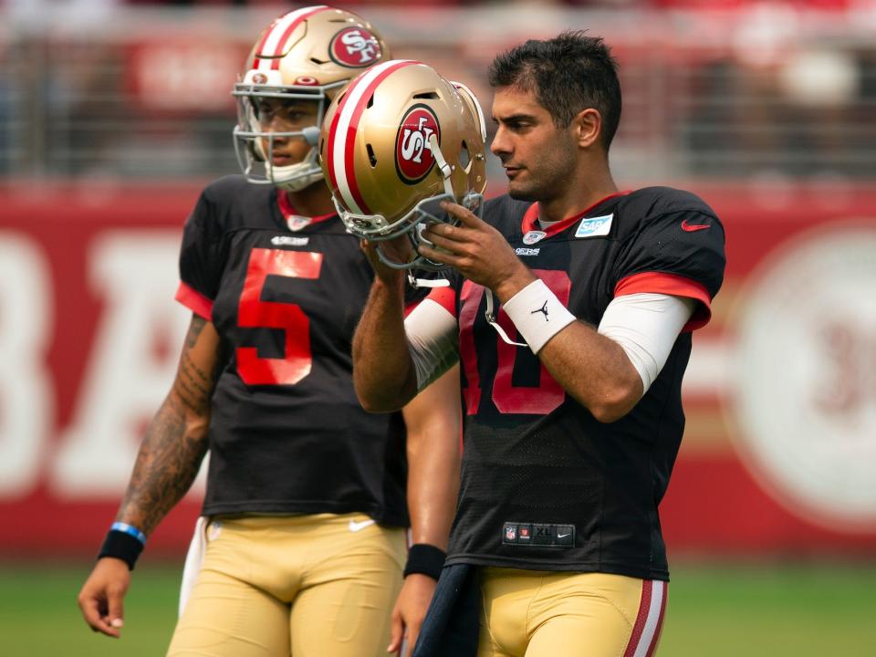 Jimmy Garoppolo and Trey Lance stand during a practice.
