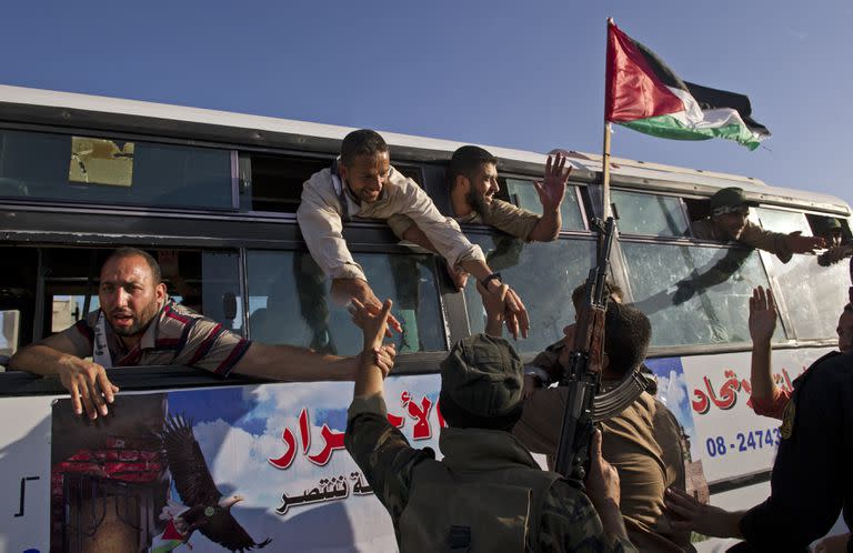 Partidarios saludan a un omnibus lleno de prisioneros que se dirigen a la ciudad de Gaza después de ser liberados a cambio del soldado israelí Gilad Shalit, en el cruce fronterizo de Rafah en el sur de la Franja de Gaza, el 18 de octubre de 2011. Hamás cambió al único soldado israelí por más más de 1000 palestinos, entre ellos Yahya Sinwar, un líder penitenciario que había participado en las negociaciones. Liberarlo fue un gran premio para Hamas, y prometió liberar a más presos.(Lynsey Addario/The New York Times)