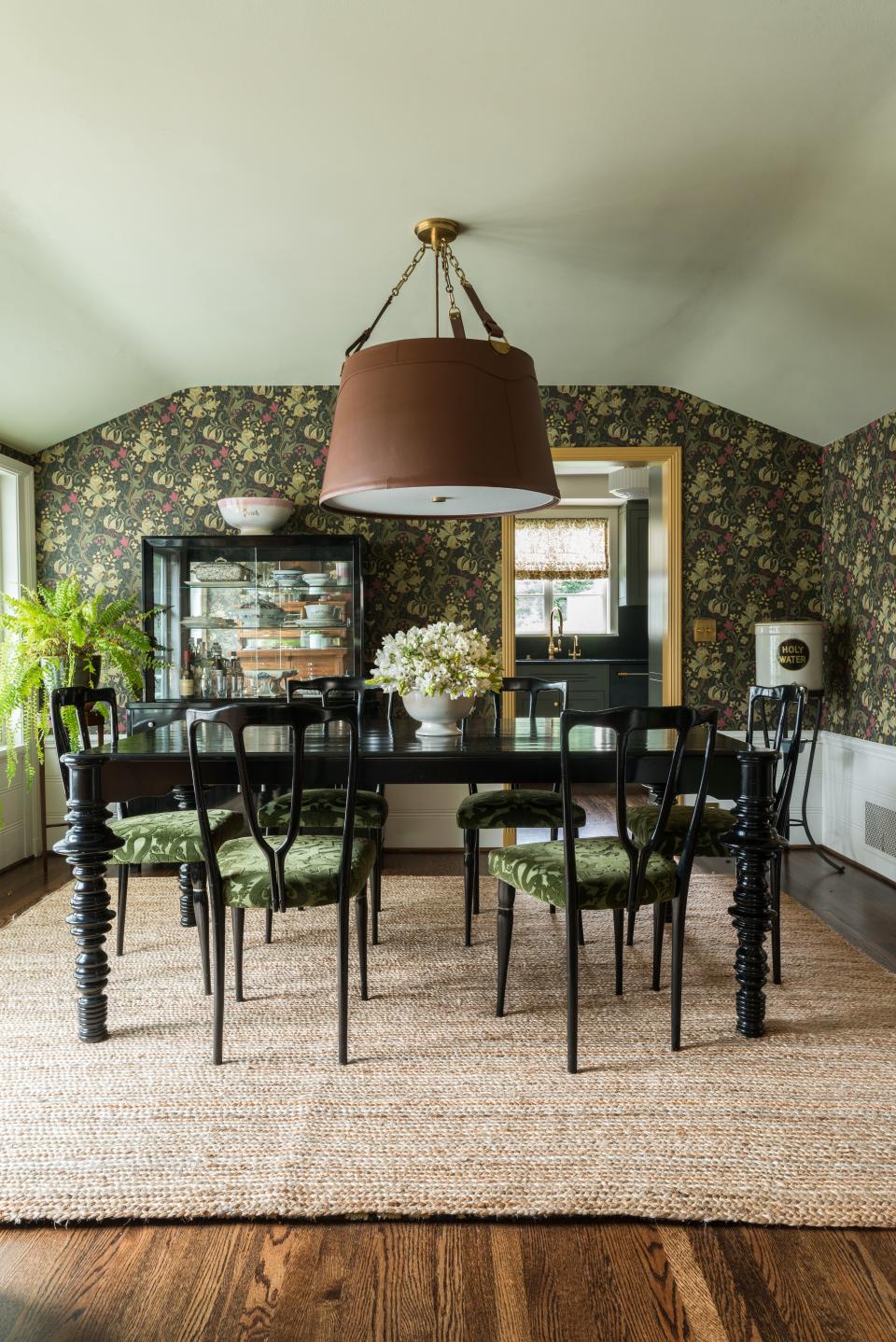 In the formal dining room of a home in Seattle’s Capitol Hill neighborhood, Studio Laloc paired the traditional arts and crafts style Morris & Co. wallpaper with furnishings that feel more modern in style, including midcentury Italian lacquered dining chairs upholstered in a cut House of Hackney velvet and a lacquered metal china cabinet. The large-scale equestrian-style pendant breaks up the black furnishings.