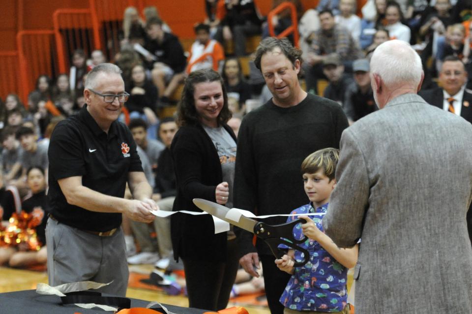 Smith Anderson, great-grandson of former Waverly coach CD Hawhee, cuts the ribbon with his father Drew and mother Alex during a ceremony dedicating the court at Waverly's Downtown Gym to his late great-grandfather on Dec. 9, 2023.