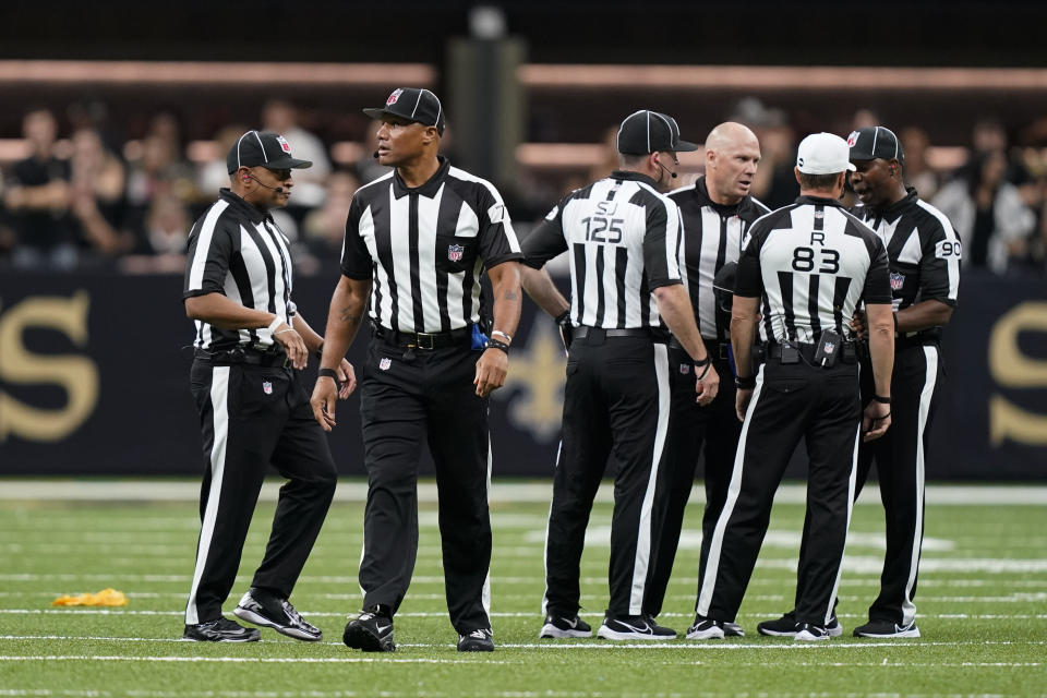 Officials meet after a brawl between the New Orleans Saints and the Tampa Bay Buccaneers during the second half of an NFL football game in New Orleans, Sunday, Sept. 18, 2022. (AP Photo/Gerald Herbert)