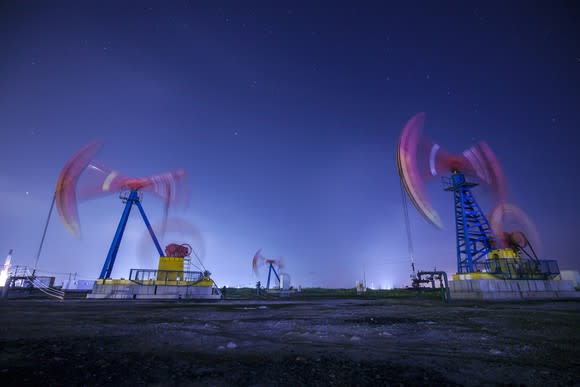 Oil pumps in motion at night.