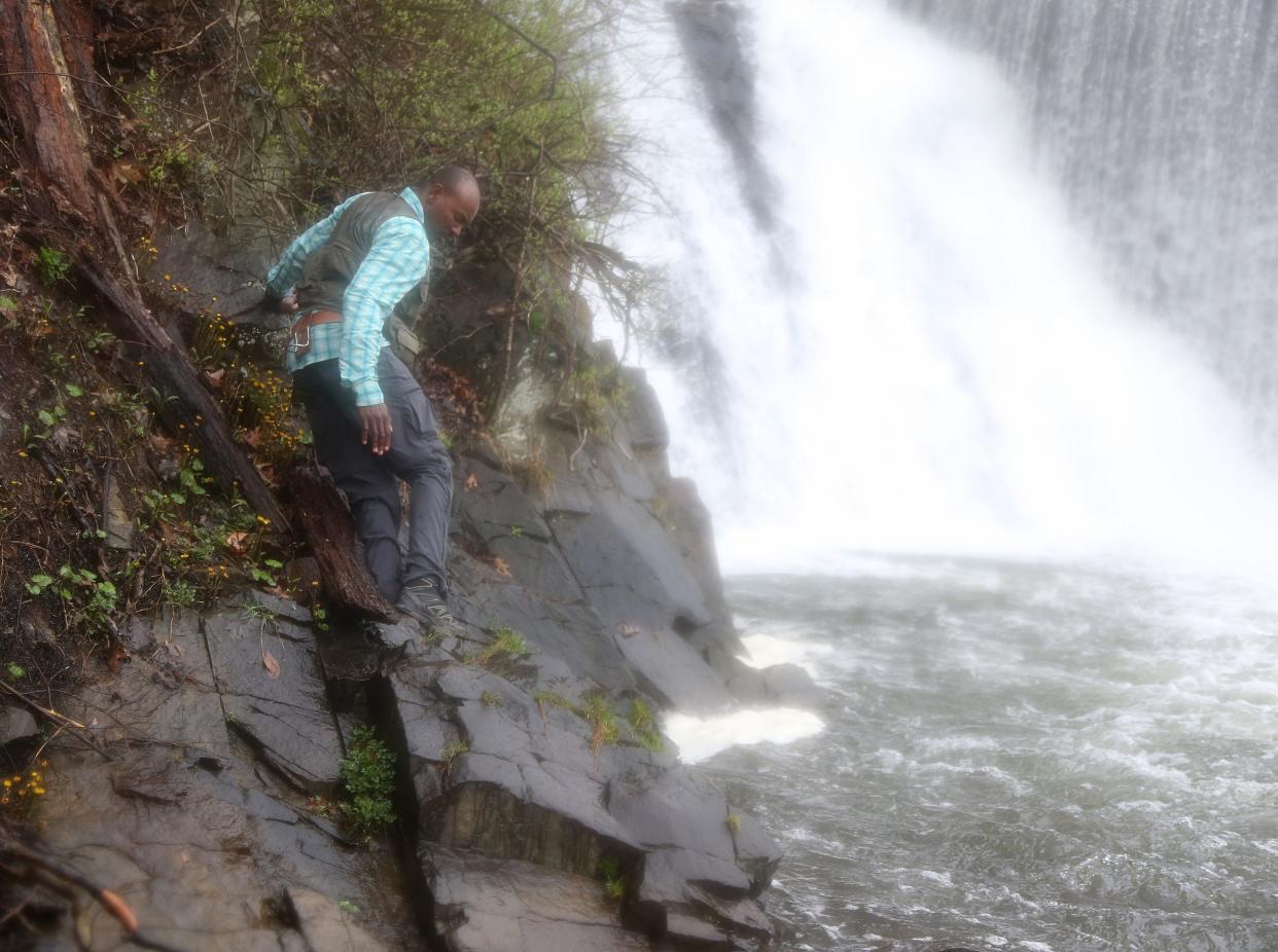 Assistant Professor of Structural Geology Folarin 'Fola' Kolawole and his staff from the Columbia University Lamont-Doherty Earth Observatory does fieldwork related to the 4.8 magnitude earthquake of April 5. Here Prof. Kolawole at the foot of the Solitude Dam in High Bridge, Hunterdon County, where he will measure cracks in the outcropping of large rocks at the foot of the falls.