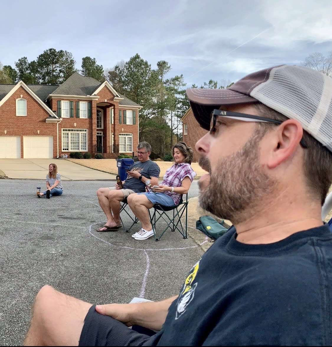 Ken Whitley and neighbors held an impromptu block party on their cul-de-sac in their metro Atlanta neighborhood, sitting in pods that are six feet apart and outlined on the street with chalk. (Credit: Heather Whitley)