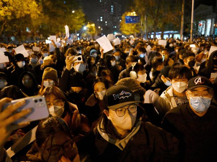 Protesters march along a street during a rally for the victims of a deadly fire as well as a protest against China's harsh Covid-19 restrictions in Beijing on November 28, 2022