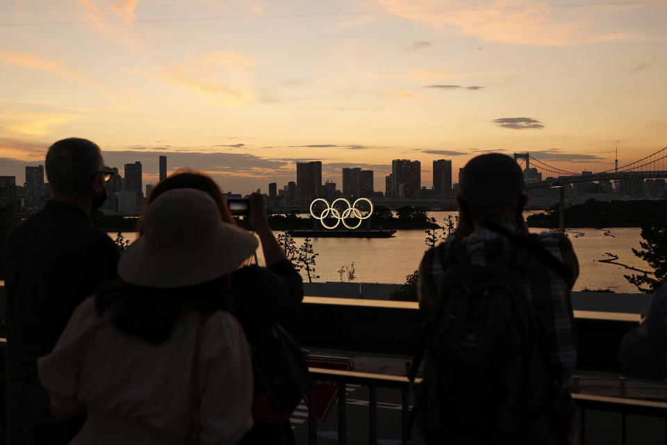 People take photos of the Olympic Rings displayed by the Odaiba Marine Park Olympic venue ahead of the Tokyo 2020 Olympic Games on July 19, 2021. (Toru Hanai / Getty Images)