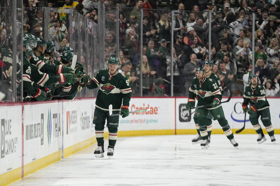 Minnesota Wild left wing Kirill Kaprizov, left, celebrates with teammates after scoring during the second period of an NHL hockey game against the Nashville Predators, Sunday, Feb. 19, 2023, in St. Paul, Minn. (AP Photo/Abbie Parr)