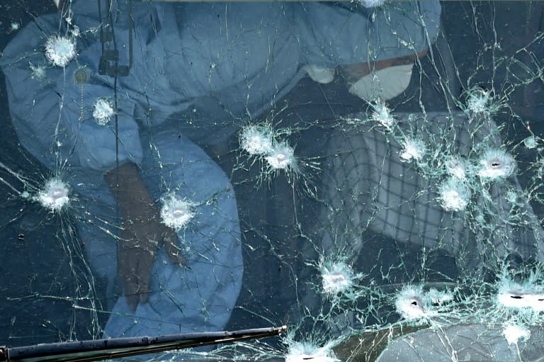 An Afghan security official inspects a bullet-riddled windscreen after a suicide attack on a bus in Kabul on May 4, 2015