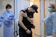 In this photo taken on Friday, Jan. 15, 2021 A Romanian gendarme leaves after getting a COVID-19 vaccine at a hospital in Bucharest, Romania. Across the Balkans and the rest of the nations in the southeastern corner of Europe, a vaccination campaign against the coronavirus is overshadowed by heated political debates or conspiracy theories that threaten to thwart the process. In countries like the Czech Republic, Serbia, Bosnia, Romania and Bulgaria, skeptics have ranged from former presidents to top athletes and doctors. Nations that once routinely went through mass inoculations under Communist leaders are deeply split over whether to take the vaccines at all. (AP Photo/Vadim Ghirda)