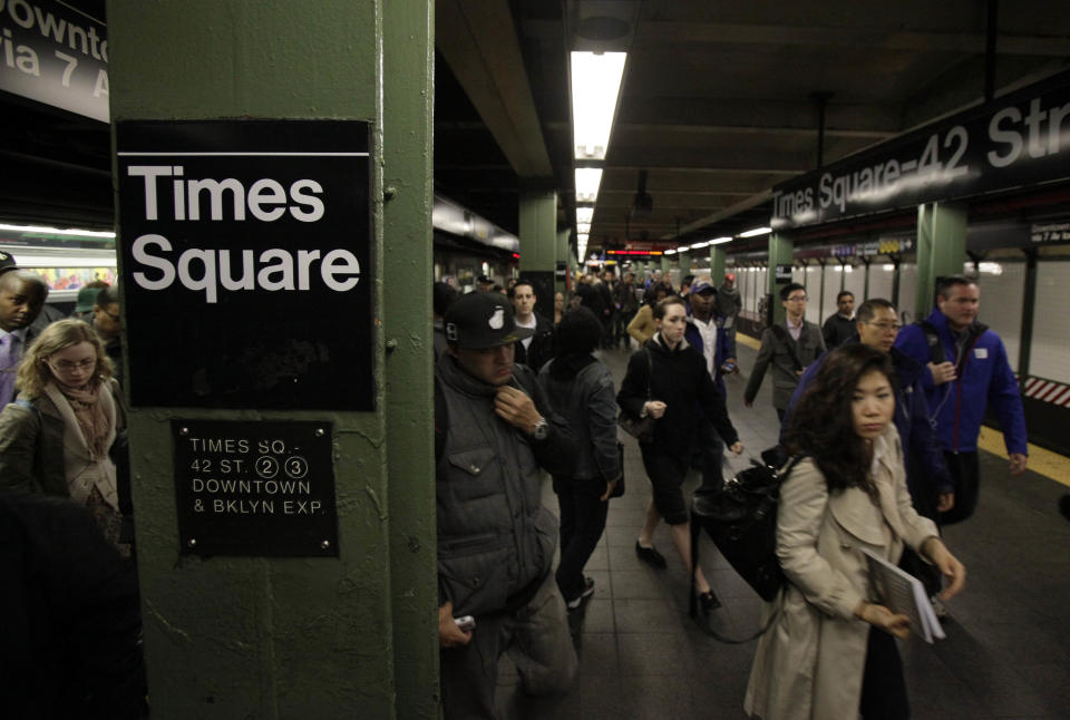 Passengers exit a downtown-bound, west side subway train in New York's Times Square,  Thursday, Nov. 1, 2012.  New York City moved closer to resuming its frenetic pace by getting back its vital subways Thursday, three days after a superstorm, but neighboring New Jersey was stunned by miles of coastal devastation and the news of thousands of people in one city still stranded by increasingly fetid flood waters.  (AP Photo/Richard Drew)