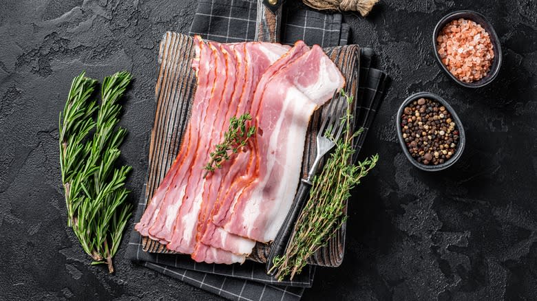 Raw bacon slices with rosemary