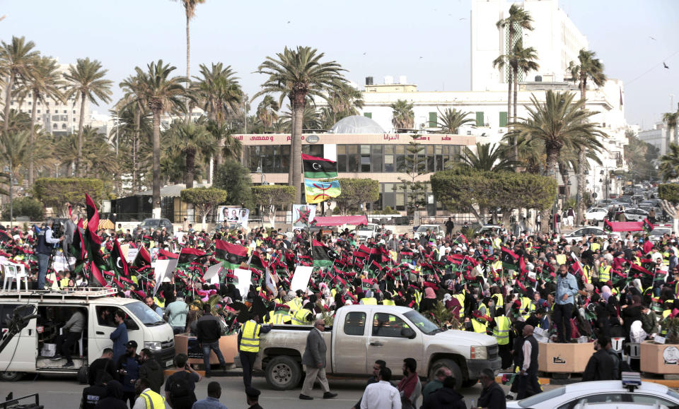 Protesters wear yellow vests at a protest in Tripoli, Libya as they wave national flags and chant slogans against Libya's Field Marshal Khalifa Hifter, who is leading an offensive to take over the capital of Tripoli, Friday, April 19, 2019. (AP Photo/Hazem Ahmed)