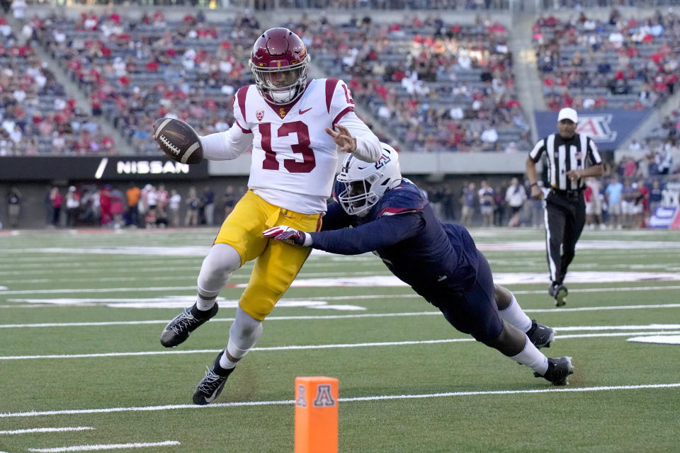 Southern California quarterback Caleb Williams (13) tries to score against Arizona defensive lineman Jalen Harris in the first half during an NCAA college football game, Saturday, Oct. 29, 2022, in Tucson, Ariz. (AP Photo/Rick Scuteri)