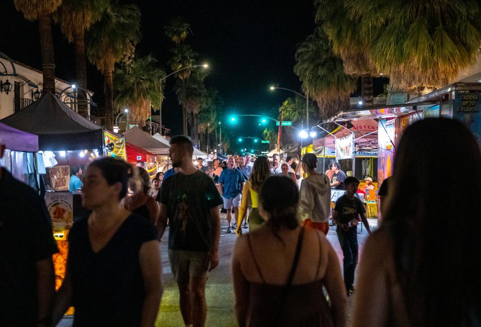 Patrons walk down the street to check out various vendors during VillageFest in downtown Palm Springs, Calif., Thursday, May 9, 2024.