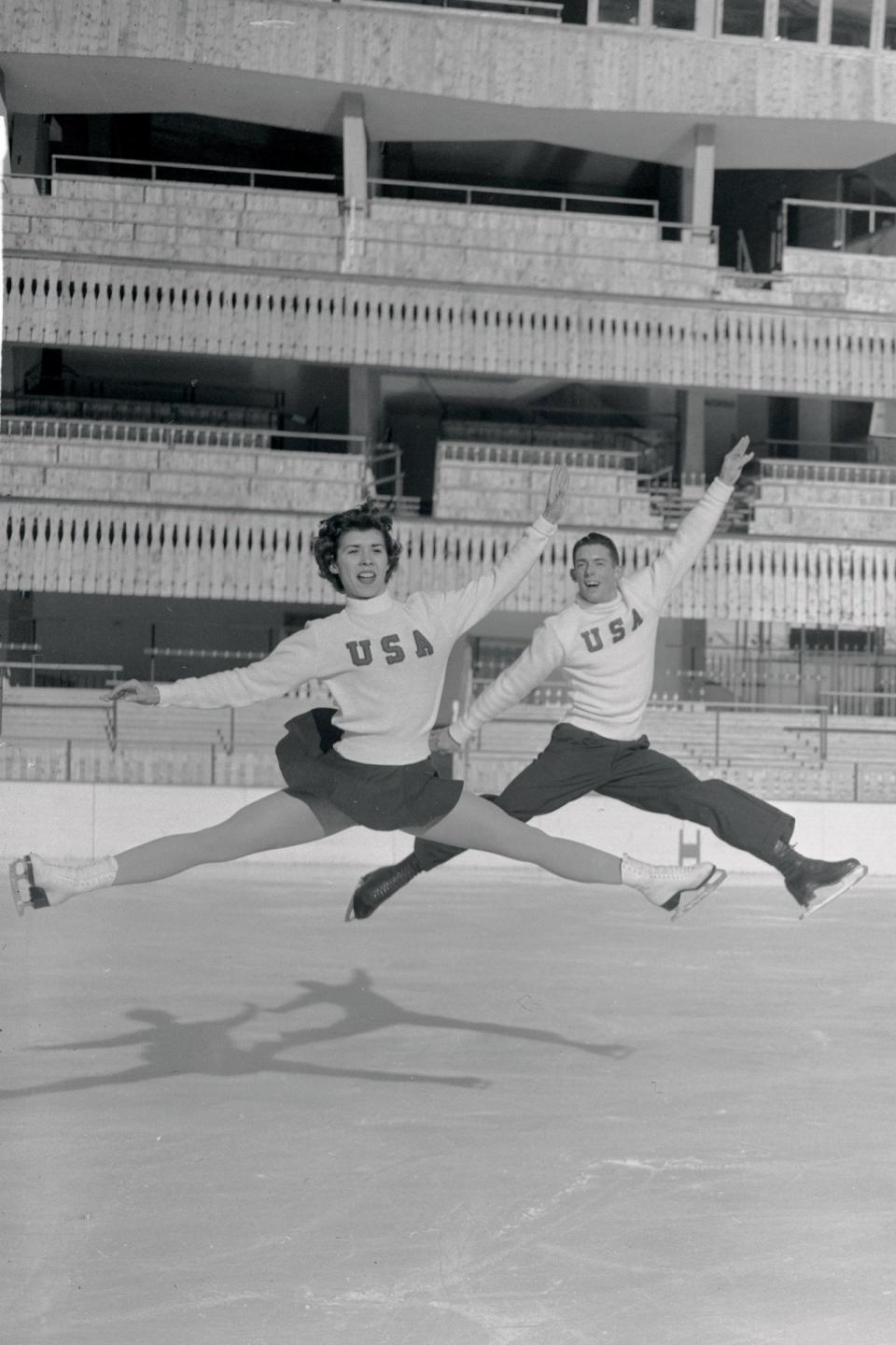 <p>American skaters Carole Ormaca and Robin Greiner get some last-minute practice in for the 1956 Winter Olympics in matching U.S.A. sweaters and dark bottoms. </p><p>By the 1940s and '50s, short skirts (rather than ankle-length) had become more frequent for women after skater <a rel="nofollow noopener" href="https://www.npr.org/sections/pictureshow/2010/02/figure_skating_fashion_through.html" target="_blank" data-ylk="slk:Sonja Henie;elm:context_link;itc:0;sec:content-canvas" class="link ">Sonja Henie</a> popularised them, and they've become a staple of women's figure skating ever since. </p>