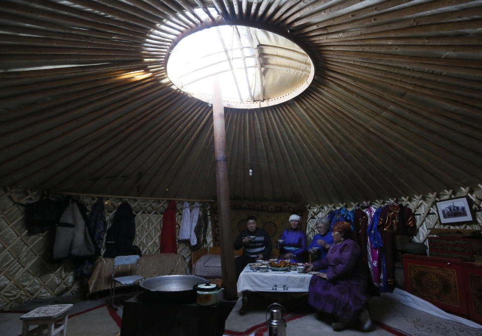 <p>Tanzurun Darisyu, right, head of a Tuvan private farm located in the Kara-Charyaa area, has a meal with her neighbours and relatives inside a yurt south of Kyzyl town, the administrative center of the Republic of Tuva (Tyva region) in southern Siberia, Russia, on Feb. 14, 2018. (Photo: Ilya Naymushin/Reuters) </p>