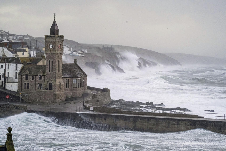 Waves hits Porthleven on the Cornish coast, Britain, as Storm Eunice makes landfall Friday, Feb. 18, 2022. Millions of Britons are being urged to cancel travel plans and stay indoors Friday amid fears of high winds and flying debris as the second major storm this week prompted a rare “red” weather warning across southern England. (Matt Keeble/PA via AP)