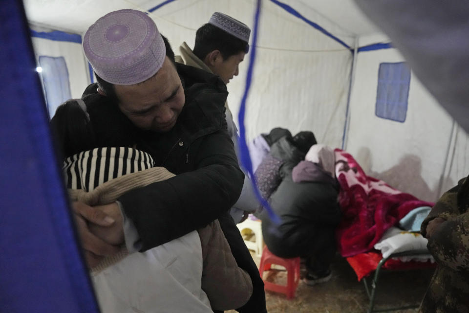 Ma Lianqiang hugs his daughter as they grieve the death of his wife and her mother who were killed by the earthquake in Yangwa village near Dahejia town in northwestern China's Gansu province, Wednesday, Dec. 20, 2023. A strong overnight earthquake rattled a mountainous region of northwestern China, authorities said Tuesday, destroying homes, leaving residents out in a below-freezing winter night and killing many in the nation's deadliest quake in nine years. (AP Photo/Ng Han Guan)