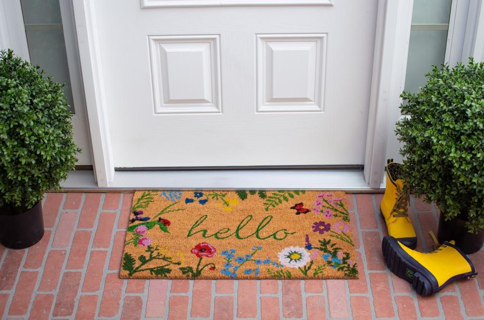 the mat with "hello" written on it and a floral pattern outside a door