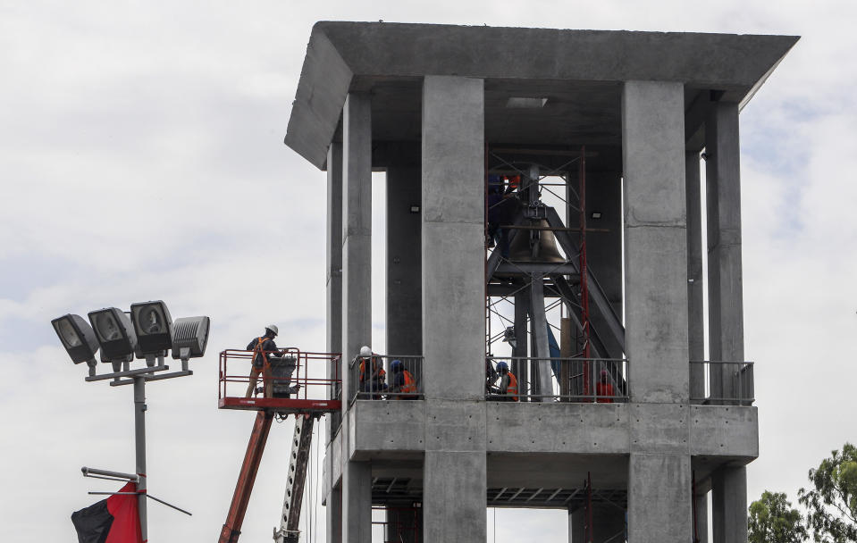 Workers ready a new monument, called the Peace Bell, before its inauguration ceremony later in the day in Managua, Nicaragua, Friday, July 17, 2020. Nicaraguan President Daniel Ortega's government is being deterred by the new coronavirus from holding the usual mass celebration to mark the victory of the country's revolution July 19, and will instead unveil a new addition to its collection of monuments. (AP Photo/Alfredo Zuniga)