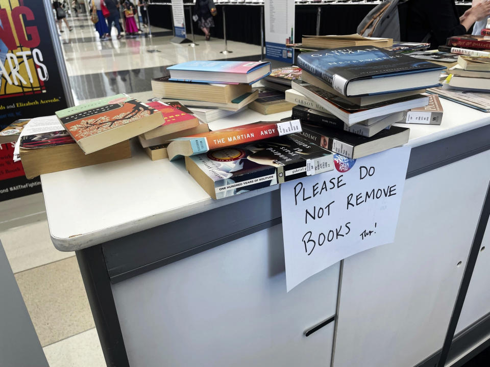 Banned books are stacked at an exhibit at the American Library Association's annual conference, Saturday, June 24, 2023, at McCormick Place in Chicago. Attendees are invited to climb atop a giant chair to read their favorite banned book. (AP Photo/Claire Savage)