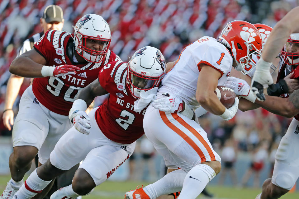 North Carolina State's Jaylon Scott (2) and Savion Jackson (90) tackle Clemson's Will Shipley (1) during the second half of an NCAA college football game in Raleigh, N.C., Saturday, Sept. 25, 2021. (AP Photo/Karl B DeBlaker)