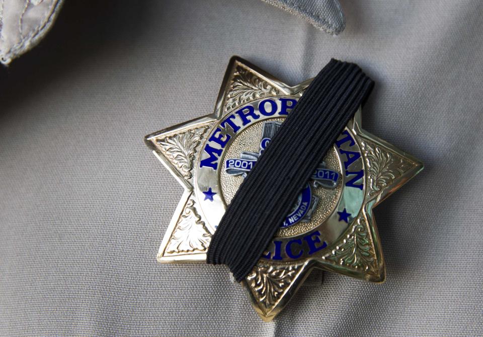 A Metro Police officer wears a ribbon over his badge at Metro headquarters as police mourn for two slain officers in Las Vegas June 8, 2014. Two suspects, also dead, shot two Metro Police officers in a pizza shop then fled to a nearby Wal-Mart where they shot and killed another person, police said. REUTERS/Las Vegas Sun/Steve Marcus (UNITED STATES - Tags: CIVIL UNREST CRIME LAW)