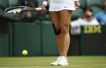 Li Na's right knee has been taped like this for about as long as she's been on the tennis radar. (AP Photo/Pavel Golovkin)