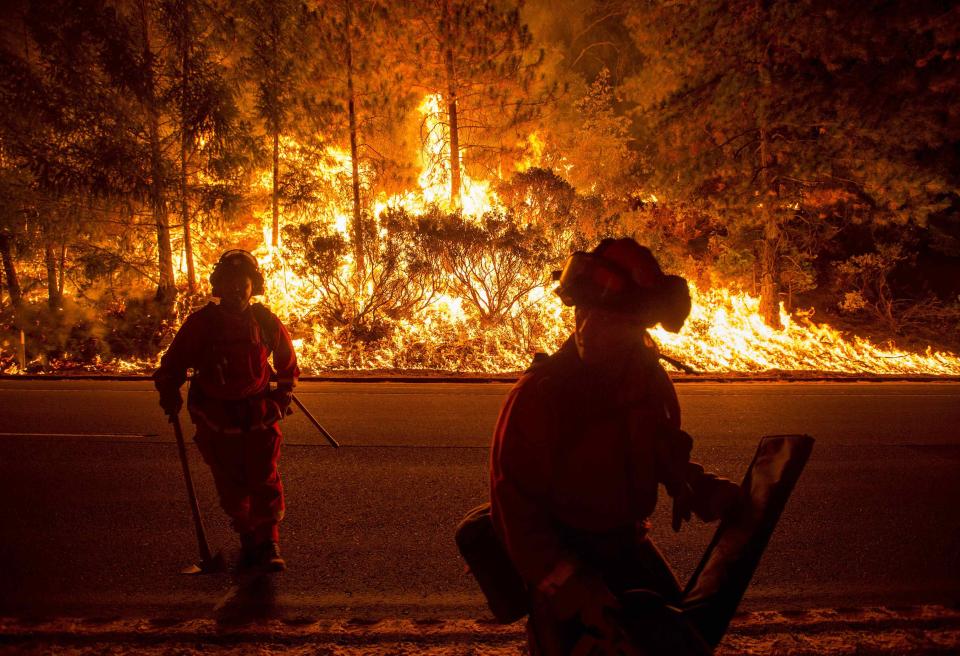 Firefighters battling the King Fire watch as a backfire burns along Highway 50 in Fresh Pond, California September 16, 2014. The fire led officials to call on about 400 people to evacuate from areas threatened by the blaze, Cal Fire spokeswoman Alyssa Smith said. It has charred more than 11,500 acres (4,654 hectares) and was 5 percent contained on Tuesday. REUTERS/Noah Berger (UNITED STATES - Tags: DISASTER ENVIRONMENT TPX IMAGES OF THE DAY)